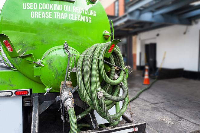 a grease trap pumping service in action at a commercial building in Angelus Oaks